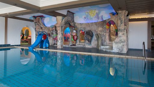 Entspannen Sie in unserem Hallen-Schwimmbad mit Panoramablick auf die Berge.