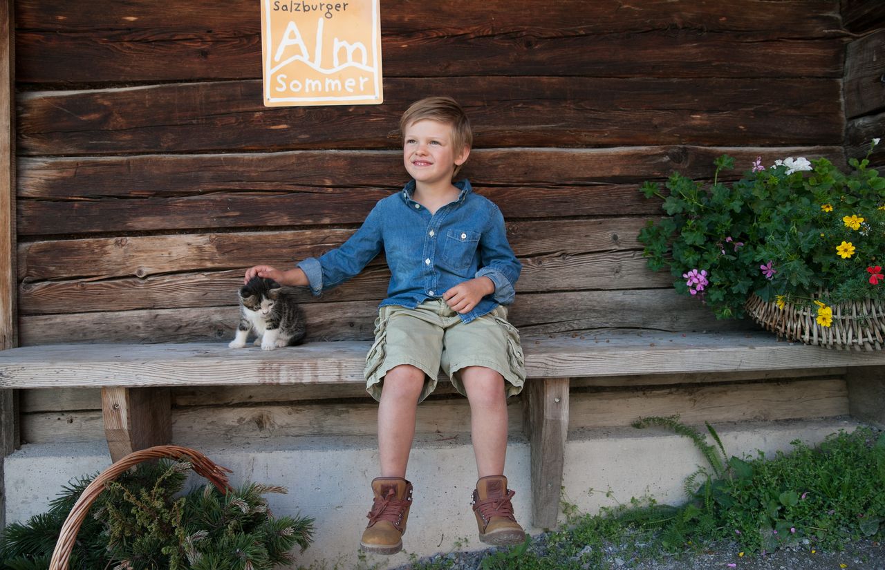 Bub mit Katze auf der Almhütte