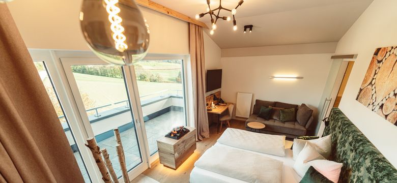 Gemütlich-modernes Doppelzimmer in braun- und Grüntönen mit freistehender Badewanne